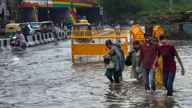 Vehicles moving through waterlogged streets in India following the official IMD Heavy Rain Alert.